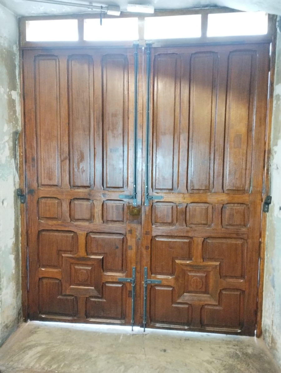Porta histórica em madeira após recuperação das folhas, ferragens e acabamento em edifício tombado